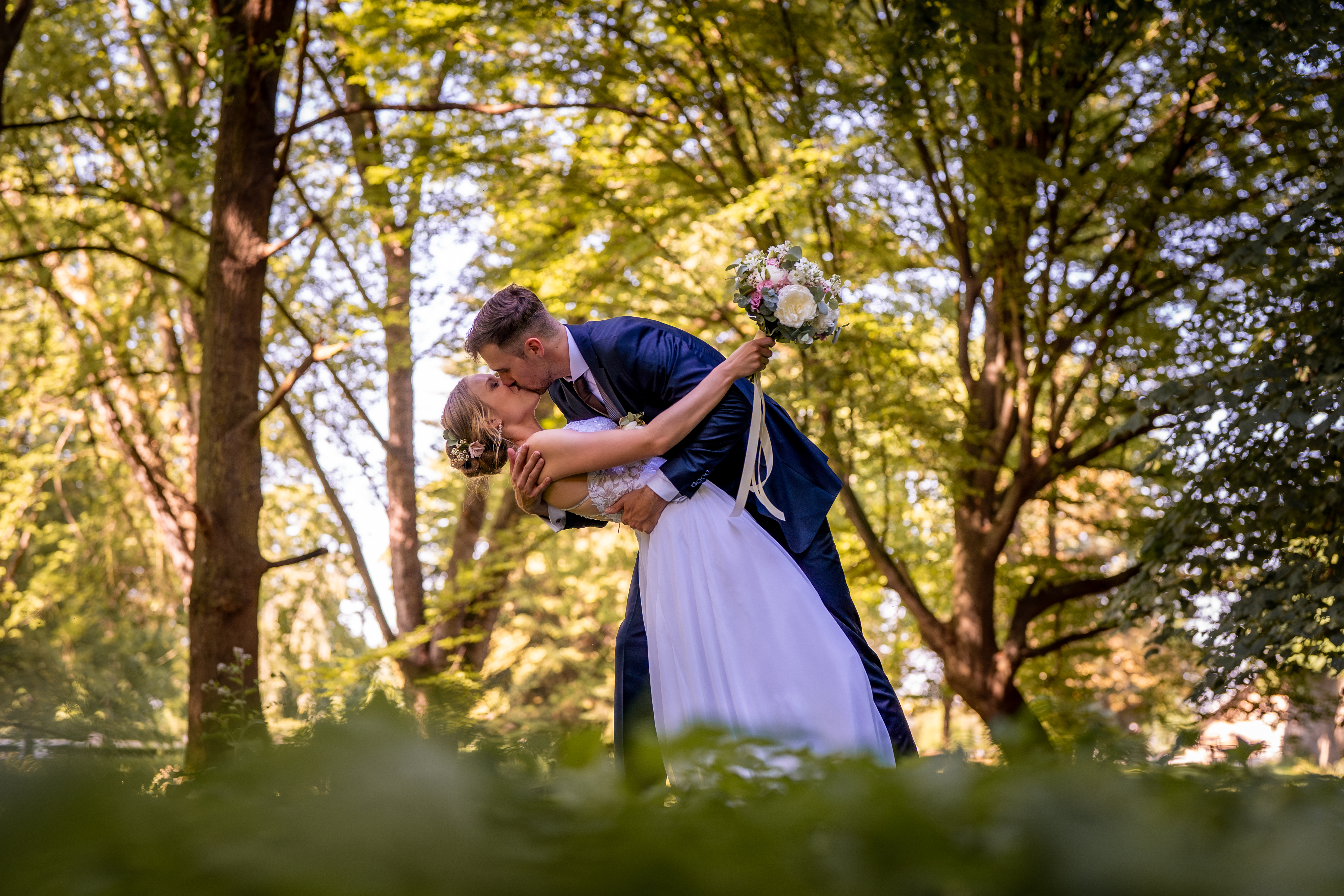 Romantic dip kiss in forest destination wedding photography Europe